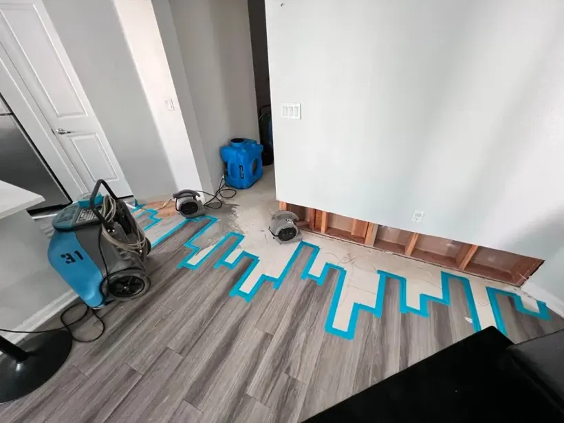 Air mover and floor-mapping tape drying a Bay Shore hardwood floor