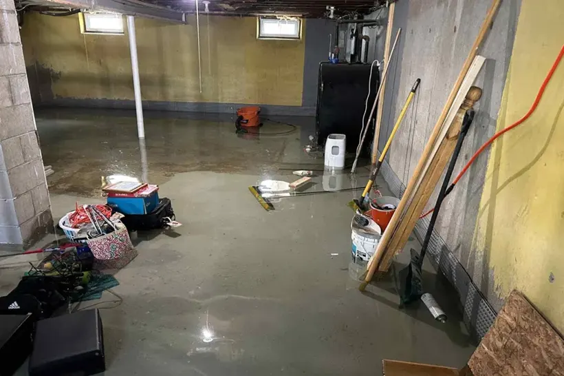 Flooded Bay Shore basement with belongings sitting in standing water