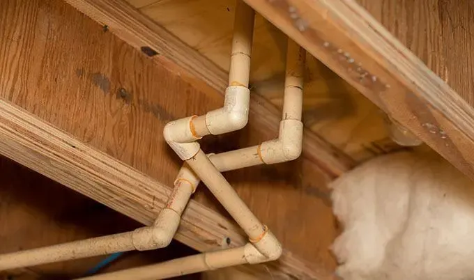 Exposed supply pipes in floor joists that froze and split in winter