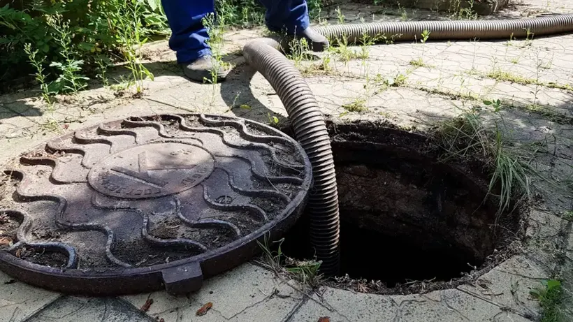 Technician clearing a sewage backup at a cleanout in Bay Shore